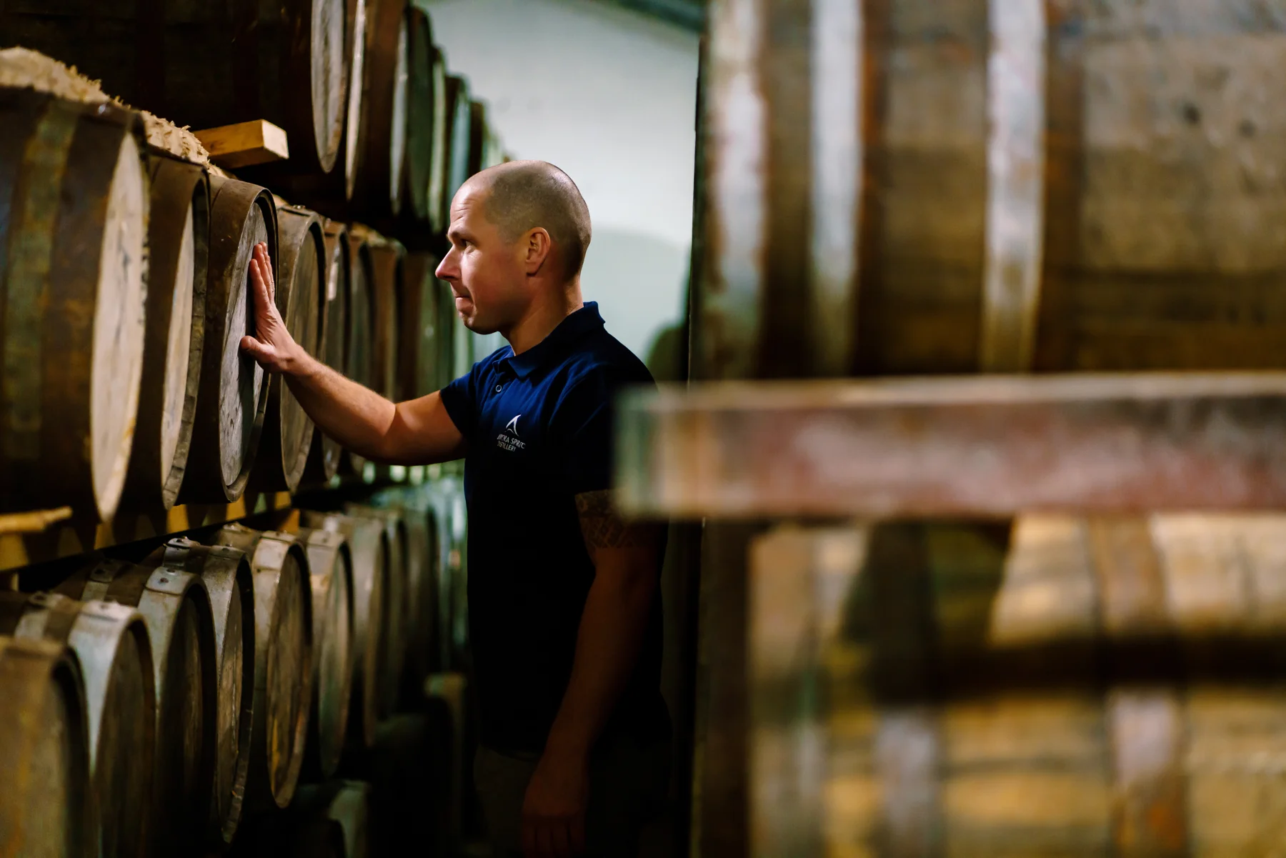 Een maker tussen de whiskyvaten bij Aurora Spirit